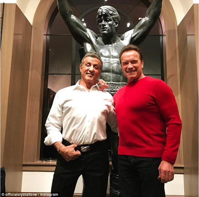 Gonna fly now: Sylvester Stallone, 71, and Arnold Schwarzenegger, 70, posed together in front of a statue of Rocky when Arnold visited Sly at his home on Christmas 