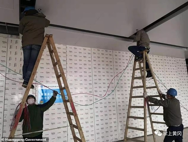 A handout from the Huanggang government shows workers from the city's electricity company working to connect the building to the grid so it can treat coronavirus patients