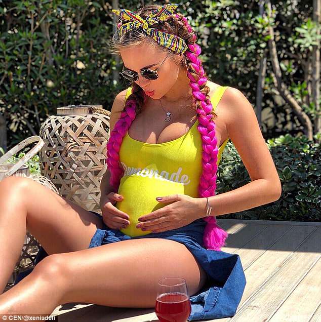 Xenia Deli, 28, is expecting her first child with her billionaire husband, posting this snapÂ of her bulging belly under a yellow top and holding her stomach to Instagram